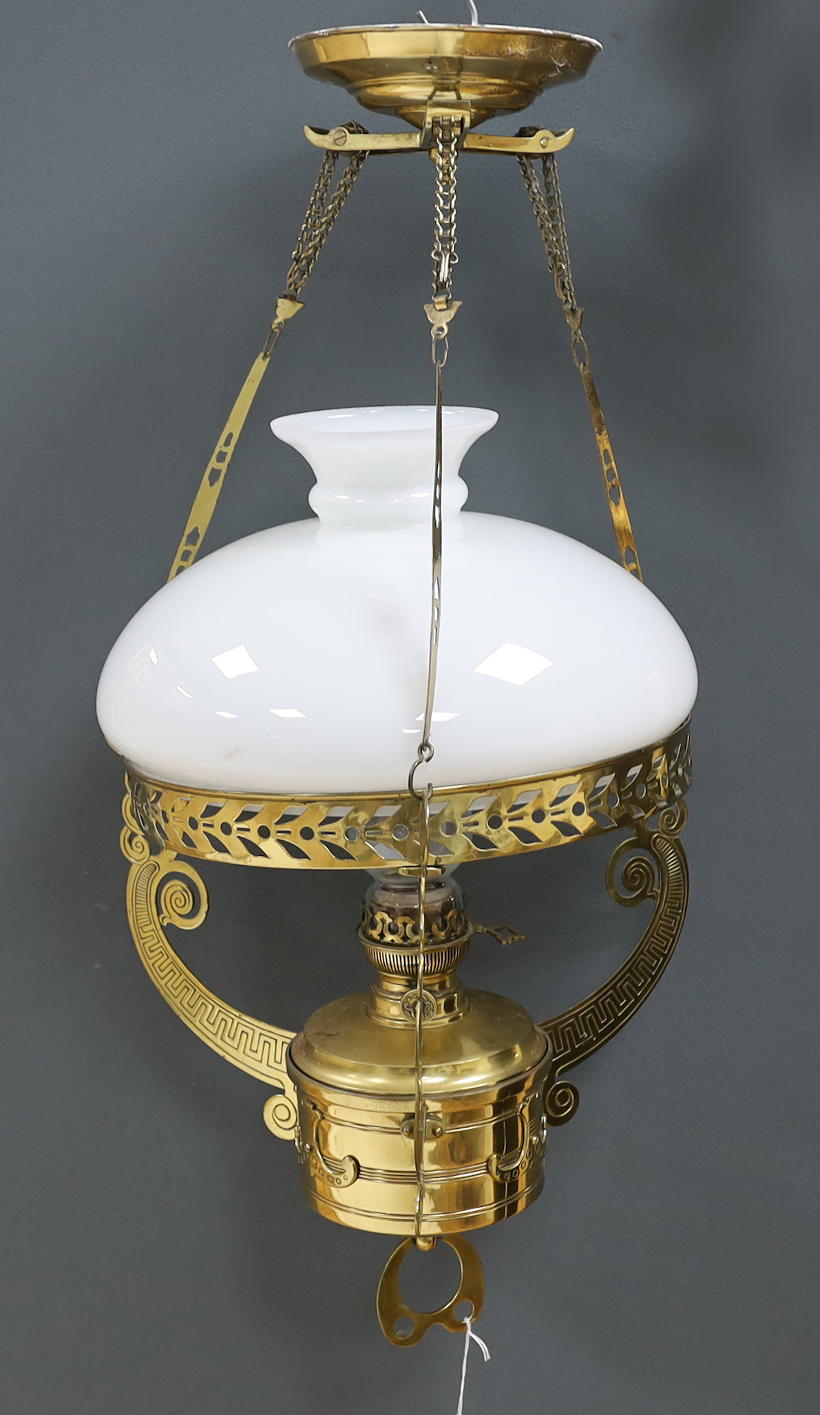 A late 19th century German brass hanging lamp, with oil reservoir and opaque glass shade, approximately 70cm long